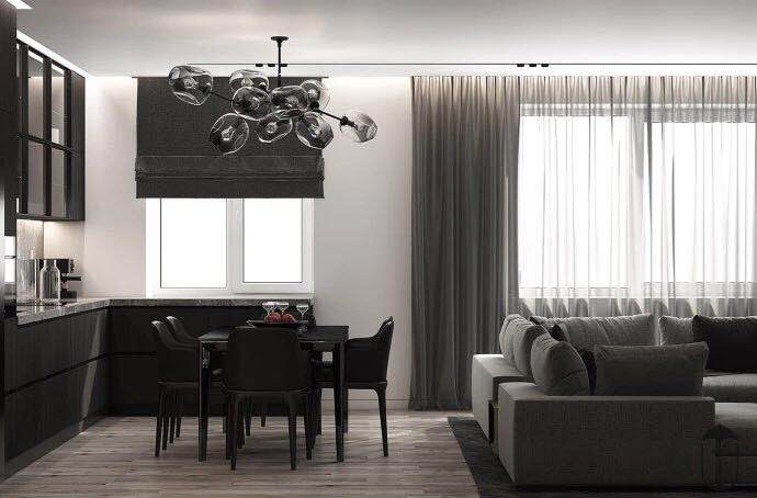 Modern kitchen and living room with dark furniture, a gray fabric sofa, a decorative chandelier, and large windows adorned with sheer curtains.