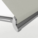 Close-up of Outdoor Pivot Arm Blinds, featuring a sleek retractable mechanism with light gray fabric and a silver metal frame set against a plain background.