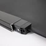 Close-up of a metal frame corner with a textured black panel and a visible screw, depicting a structural or assembly detail.