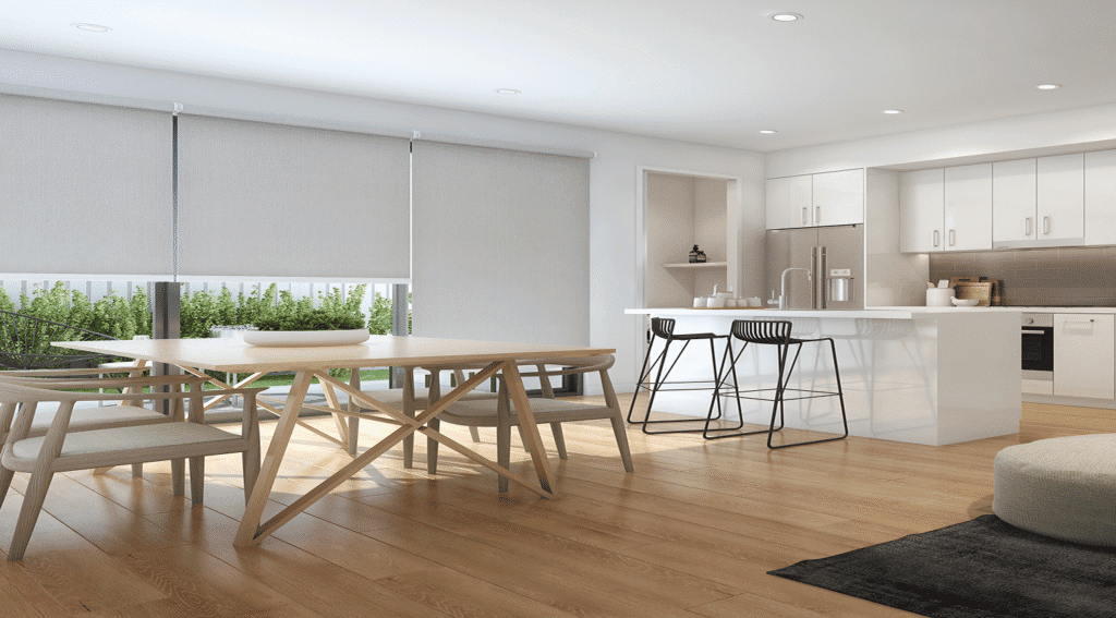 Modern kitchen and dining area with light wood floors, white cabinets, an island with two barstools, a four-seat dining table, and large windows featuring Builders' Range Roller Blinds.