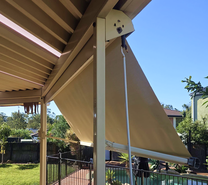 Beige retractable outdoor awning extended from a patio roof.